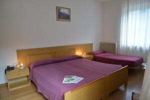 1 dormitorio con 2 camas con sábanas moradas en Hotel Bel Sit en Comano Terme