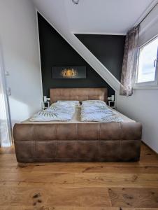 Un dormitorio con una cama de cuero marrón en una habitación en Ferienhof-Dachsberg Wohnung Highlander, en Bermatingen