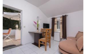 a living room with a desk and a couch at Cozy Apartment In Zuljana With Wifi in Žuljana