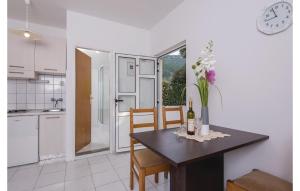 a kitchen and dining room with a table with flowers on it at Cozy Apartment In Zuljana With Wifi in Žuljana