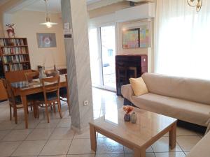 Central Home Kavala "private parking" في كافالا: غرفة معيشة مع أريكة وطاولة