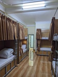 a room with three bunk beds and a hallway at Train Station Backpackers Hostel in Ninh Binh