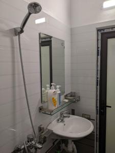 a white bathroom with a sink and a mirror at Train Station Backpackers Hostel in Ninh Binh