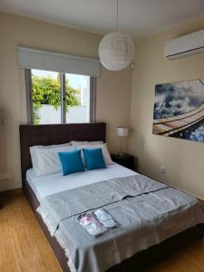 a bedroom with a large bed with blue pillows at Villa utopia in Paphos City