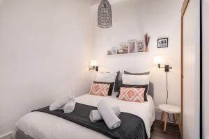 een slaapkamer met een groot wit bed met kussens bij Le 14 Sathonay in Lyon