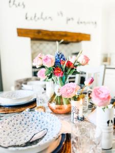 a table with plates and flowers on it at Pen Y Bont Cottage in Llanuwchllyn