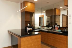 a kitchen with wooden cabinets and a black counter top at Dua Sentral by Cobnb in Kuala Lumpur