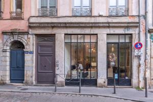 una tienda al lado de un edificio con una puerta en Le 14 Sathonay, en Lyon