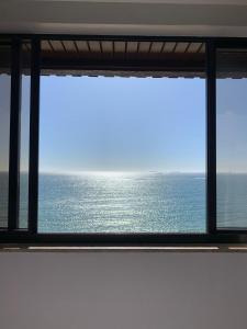 a view of the ocean from a window at Praia da Costa, SUNRISE STAY in Vila Velha