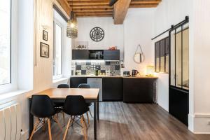 cocina y comedor con mesa y sillas en Le 14 Sathonay, en Lyon