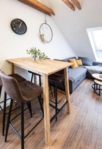 een woonkamer met een houten tafel en een bank bij Gemütliches Loft-Retreat in Treuchtlingen
