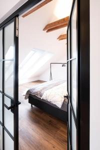een slaapkamer met een bed en een glazen deur bij Gemütliches Loft-Retreat in Treuchtlingen