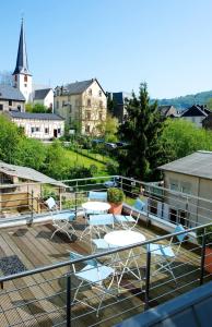 a deck with chairs and tables and a church at Hotel Trabener Hof in Traben-Trarbach