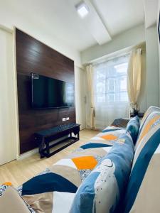 a living room with two beds and a flat screen tv at Functional 1-br Space in Amaia with Fast Internet in Mandaue City