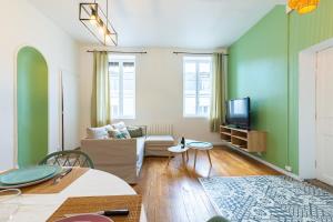 uma sala de estar com um sofá e uma televisão em Côté Cour - Centre Ville- Calme - Charme - 4 Voyageurs em Dijon
