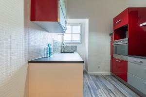 une cuisine avec des placards rouges et un comptoir dans l'établissement Côté Cour - Centre Ville- Calme - Charme - 4 Voyageurs, à Dijon