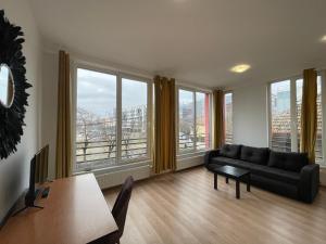 a living room with a couch and large windows at NEW Central nr2 Self Checkin OldCity Center Paid Parking with Lift in Timişoara