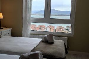 - une chambre avec un lit et une grande fenêtre dans l'établissement C01A05 Precioso apartamento con vistas al mar, à Santander