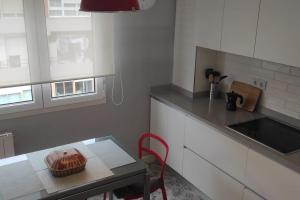 une cuisine avec une table et une chaise rouge dans l'établissement C01A05 Precioso apartamento con vistas al mar, à Santander