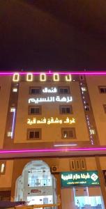 a building with purple lights on top of it at فندق نزهة النسيم in Ash Shishah