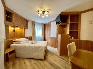 B&B Family Accommodation Canazei BIKE FRIENDLY في كنازاي: غرفة نوم بسرير وطاولة