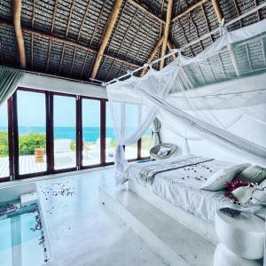 una camera da letto con amaca e vista sull'oceano di Mar-Me-Quer, Eco Beach Retreat a Inhambane