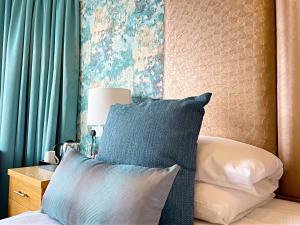 a bedroom with a bed with a blue and white pillow at Caerwylan Hotel in Criccieth