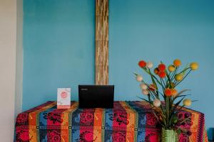 a table with a laptop and a vase with flowers at OYO 1784 Hj. Aniek Residence in Madiun