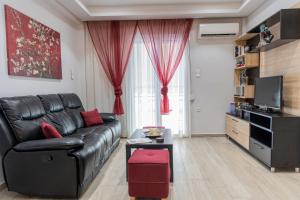 uma sala de estar com um sofá de couro preto e almofadas vermelhas em Piraeus Port Exclusive em Piraeus