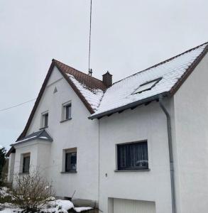 una casa blanca con nieve en el techo en Ferienwohnung Maldener 