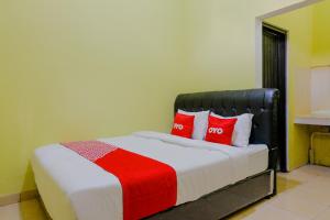 a bedroom with a bed with red pillows at OYO 1784 Hj. Aniek Residence in Madiun