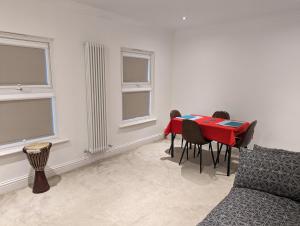 a dining room with a red table and chairs at Fully-equipped flat in the city of London in London