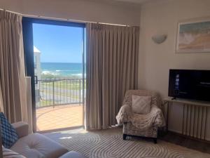 een woonkamer met een stoel en een groot raam bij Ocean Views - Top floor in Alexandra Headland