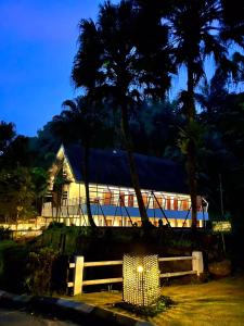 a train parked in front of a building with palm trees at Lembah Permai Resort in Sindanglaya