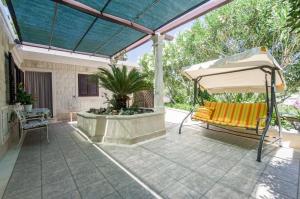 a patio with a white umbrella and a bench at Holiday home Villa Spilla in Selca
