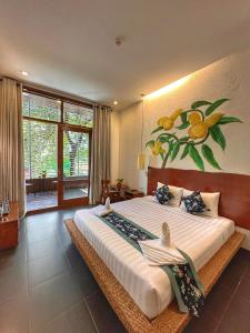 a bedroom with a large bed with a painting on the wall at Monsoon Riverside Hotel in Phnom Penh