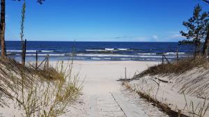 a path to the beach with the ocean in the background at Apartament na Zaciszu in Kąty Rybackie