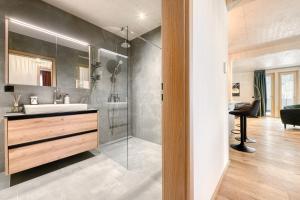a bathroom with a sink and a glass shower at Familienferienwohnung Zentral by A-Appartments in Brand