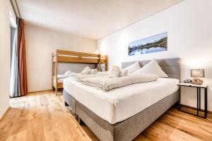 um quarto com uma grande cama branca num quarto em Familienferienwohnung Zentral by A-Appartments em Brand
