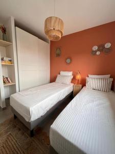 two beds in a room with orange walls at Casa Agatha : Villa avec piscine in Figari