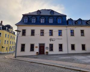 a white building with a blue roof on a street at Gästehaus 1979 in Schneeberg