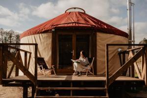 バウチュにあるGlamping jurty Czaplaのパオの前に座る女