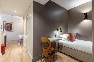 a bedroom with a bed and a desk and a chair at Le Nest by Sweet Inn in Paris