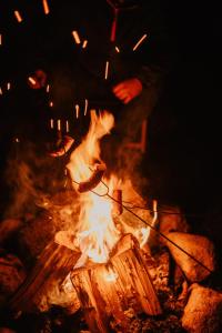 Ogień z osobą stojącą nad nim w obiekcie Glamping jurty Czapla w Wałczu