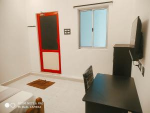 a room with a door and a table and a window at BlueMoon Homestay in Puducherry