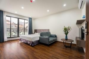 um quarto com uma cama, um sofá e uma televisão em Granda Lake View Hotel & Apartment em Hanói