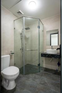 uma casa de banho com um chuveiro, um WC e um lavatório. em Granda Lake View Hotel & Apartment em Hanói
