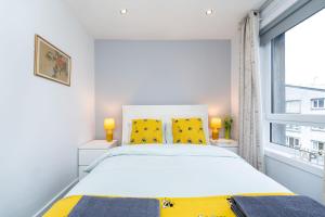 een witte slaapkamer met een groot bed en een raam bij Lovely 3-bedroom flat with free parking in Bridge of Allan