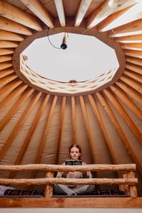 a woman sitting in a room in a yurt at Łąka Gwiazd Jurty Czapla in Wałcz
