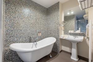 La salle de bains est pourvue d'une baignoire et d'un lavabo. dans l'établissement Le Nest by Sweet Inn, à Paris